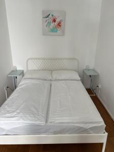 a white bed in a room with two tables at Apartment NUMBER 17 in Vienna