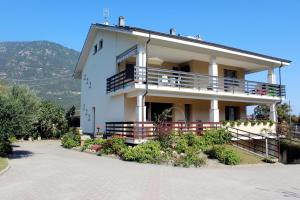 a white house with a balcony on the side of it at Fior di Loto Apartment in Villar Focchiardo