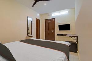 um quarto com uma cama grande e uma televisão em Super OYO Flagship Rsd Grand em Gunadala