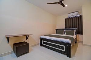 niewielka sypialnia z łóżkiem i stołem w obiekcie Super OYO Flagship Rsd Grand w mieście Gunadala