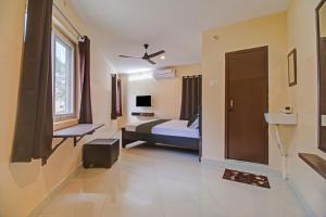 um quarto de hotel com uma cama e uma janela em Super OYO Flagship Rsd Grand em Gunadala