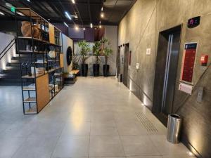 um corredor vazio num edifício com escadas e plantas em Studio Alpha Stay One em Barueri
