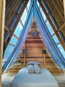 a bedroom with a bed in a wooden cabin at Sirus Base Camp Tagulandang in Kisihang