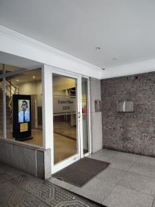 una entrada a un edificio con un cartel en la ventana en Departamento la feliz en Mar del Plata