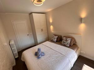 Un dormitorio con una cama con un par de zapatos. en Les Arènes - Cannes centre, Charmant 2 pièces récemment rénové de 45 m2 avec sa terrasse de 10 m2 en Cannes