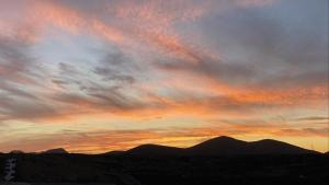a sunset in the sky with mountains in the background at Casa Saboa in San Bartolomé