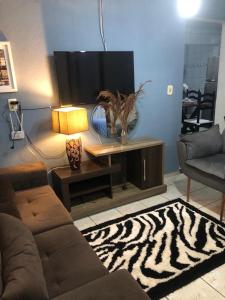a living room with a couch and a zebra rug at Sandra House Pipa in Pipa +11 photos