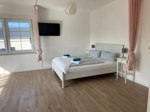 a white bedroom with a bed and a window at Seeblick Apartments Mühlau in Mühlau