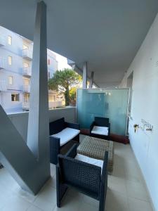 Un balcón con 2 mesas y sillas en un edificio en Residence La Settima, en Milano Marittima