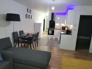 uma sala de estar e cozinha com mesa e cadeiras em Park view apartment em Manchester