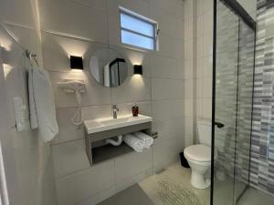 a bathroom with a sink and a toilet and a mirror at VILLA BILAC 03 - Studio próximo à Vila Germânica in Blumenau +28 photos