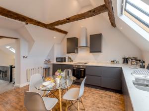 a kitchen with a glass table and white chairs at Pass the Keys 5C Charming Town Centre Apartment With Roof Top Views in Shrewsbury