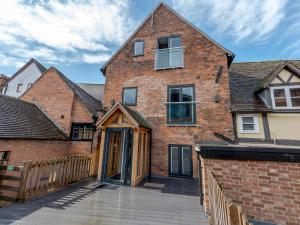 an exterior view of a brick house with a wooden door at Pass the Keys 5C Charming Town Centre Apartment With Roof Top Views in Shrewsbury