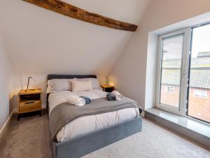 a bedroom with a bed and a large window at Pass the Keys 5C Charming Town Centre Apartment With Roof Top Views in Shrewsbury