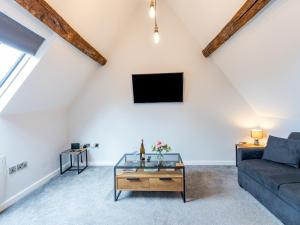 a living room with a couch and a tv at Pass the Keys 5C Charming Town Centre Apartment With Roof Top Views in Shrewsbury