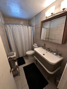 a bathroom with a sink and a toilet and a mirror at Charming 2 Bed Mid-City Living only 7 Min to Downtown in Tucson