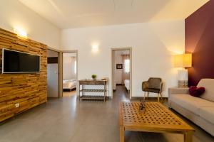 ein Wohnzimmer mit einem Sofa und einem TV an der Wand in der Unterkunft Résidence Dolce Vita de Palombaggia in Porto-Vecchio
