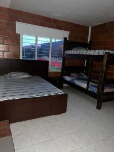 Cette chambre comprend 2 lits superposés et un mur en briques. dans l'établissement Villa Amor - Queremal, à El Queremal