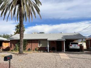 a house with a palm tree in front of it at Charming 2 Bed Mid-City Living only 7 Min to Downtown in Tucson