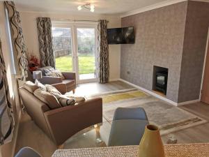 a living room with a couch and a fireplace at The Annexe in Swanton Morley. in Swanton Morley