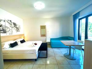 1 dormitorio con cama, mesa y sofá azul en Resort Park Village, en Rossano