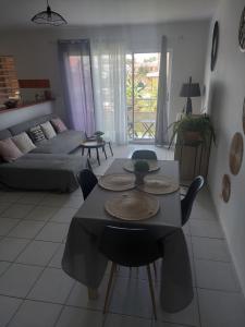 - un salon avec une table, des chaises et un canapé dans l'établissement T2 COSY, LUMINEUX ET SPACIEUX, à Cayenne