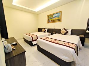 a hotel room with two beds in a room at Volga Hotel in Vung Tau