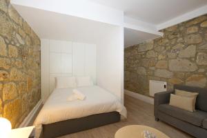 ポルトにあるLargo São Domingos by Innapartmentsの小さなベッドルーム(ベッド1台、ソファ付)