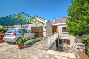 a car parked in the driveway of a house at Apartments Marja in Njivice