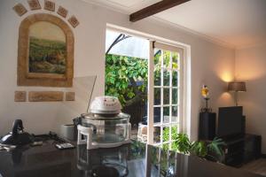 een keuken met een glazen tafel en een raam bij Nirvana Cottage in Kaapstad