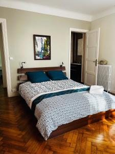 - une chambre avec un grand lit et des oreillers bleus dans l'établissement Grand appartement Athis Mons proche Paris, à Athis-Mons
