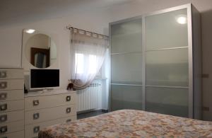 - une chambre avec un lit et une commode avec un miroir dans l'établissement Fior di Loto Apartment, à Villar Focchiardo