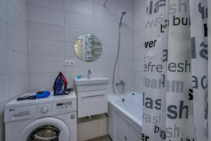 baño blanco con lavadora y lavamanos en Asaapart Mega Studio 1, en Almaty