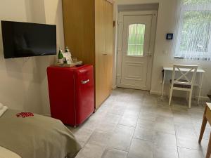 um quarto com um frigorífico vermelho e uma televisão em Hotel Himmel und Havel em Berlim