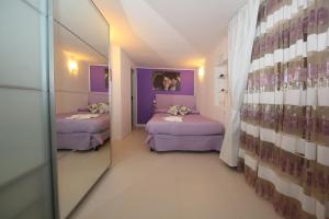 ローマにあるL'Isola di Esmeの紫の壁の客室で、ベッド2台が備わります。