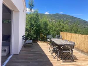 un patio avec une table et des chaises et une montagne dans l'établissement Petite maison avec terrasse., à Ajaccio
