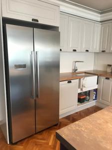 a stainless steel refrigerator in a kitchen with white cabinets at Comfortable accommodation and nearby attractions in Istanbul