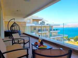 un balcón con sillas y una mesa con un bol de fruta en Yalarent Europe apartments- Luxury big apartmens with lake view, en Tiberíades