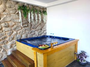 bañera de hidromasaje en una habitación con pared de piedra en Yalarent Europe apartments- Luxury big apartmens with lake view, en Tiberíades