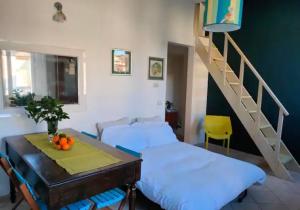 um quarto com duas camas e uma mesa e uma escada em Magnificat's Apartment em Florença