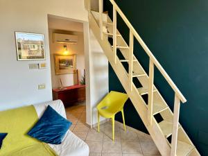 uma sala de estar com uma escada e uma cadeira amarela em Magnificat's Apartment em Florença