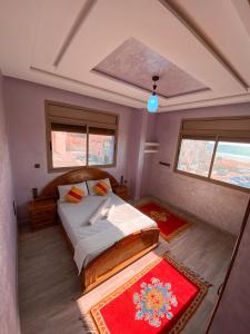 um quarto com uma cama e duas janelas em Amouage Surf House Anza em Agadir