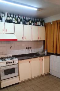 a kitchen with white cabinets and bottles of wine at Casa Familiar para hasta 6 personas , Lujan de Cuyo , Mendoza in Ciudad Lujan de Cuyo