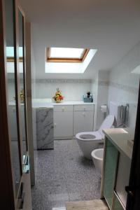 La salle de bains est pourvue de toilettes, d'un lavabo et d'une lucarne. dans l'établissement Fior di Loto Apartment, à Villar Focchiardo
