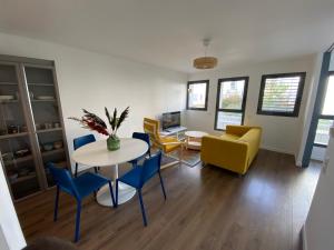 Una sala de estar con una mesa y sillas y un sofá. en Haut Standing Suresnes, en Suresnes