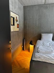 um quarto com uma cama branca e piso em madeira em Marselisborg Allé 9 B em Arhus