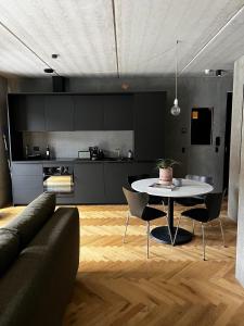 uma sala de estar com uma mesa e uma cozinha em Marselisborg Allé 9 B em Arhus