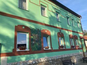 Penzion Romeo في Mladeč: مبنى شبابيكه وزهور جانبيه