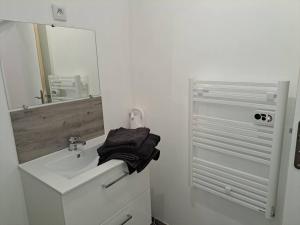 a white bathroom with a sink and a mirror at BudgetBnb 162, Studio opéra in Toulon