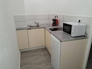 a small kitchen with a microwave and a sink at BudgetBnb 162, Studio opéra in Toulon